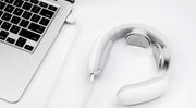 Cervical & Shoulder Massager with remote control next to a laptop, showcasing USB charging design.