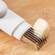 3-in-1 rotating stainless steel peeler on wooden surface slicing garlic.