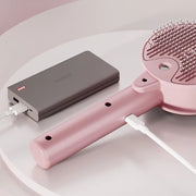 Cat Dog Steamy Brush electric sprayer in pink, charging via power bank for pet grooming and massage.