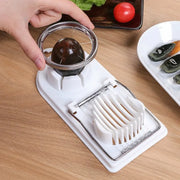 Stainless steel egg slicer cutting a boiled egg, versatile kitchen tool on wooden countertop.