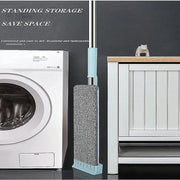 Newest Microfiber Flat Mop with washable pad standing upright for easy storage beside a washing machine.