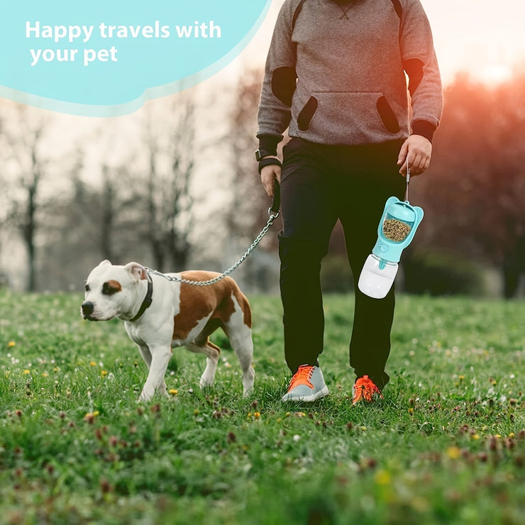 Portable dog water bottle with food container, used by person walking dog outdoors.